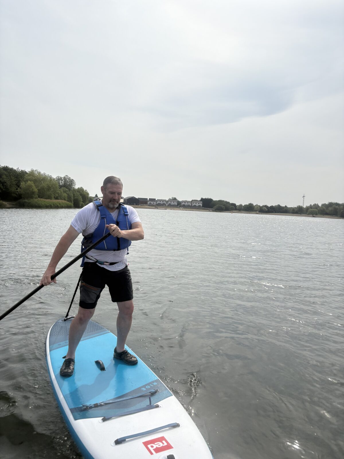Paddleboarder wearing a visible buoyancy aid on open water